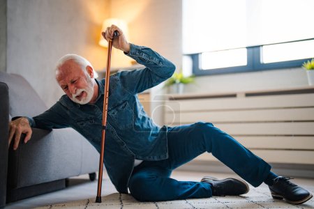 Foto de Hombre mayor cayendo al suelo con caminante en la sala de estar en casa. Pacientes de edad avanzada hombre maduro que tiene un ataque al corazón accidente para el apoyo de ayuda de emergencia del hospital. Seguro de salud. - Imagen libre de derechos