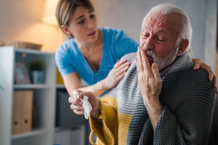 Photo for Doctor consoling senior patient at home. Old people senior man with winter seasonal illness fever cold problems. Concept of mature retired with disease. Front view of senior man coughing - Royalty Free Image