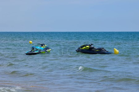 Two Personal Watercraft (jet ski) waiting for riders in front of the beach in Valencia