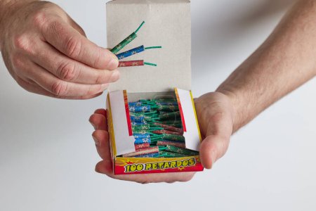A man opens a box of firecrackers. Close-up of a man's hands opening a box.