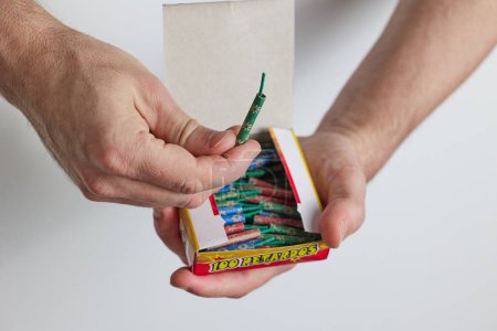 A man opens a box of firecrackers. Close-up of a man's hands opening a box.