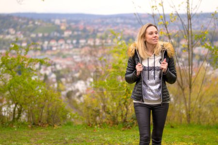 Téléchargez les photos : Jolie femme blonde dans la quarantaine portant une tenue en cuir avec les deux mains à la mode sur sa veste sur une montagne près de Stuttgart en Allemagne - en image libre de droit