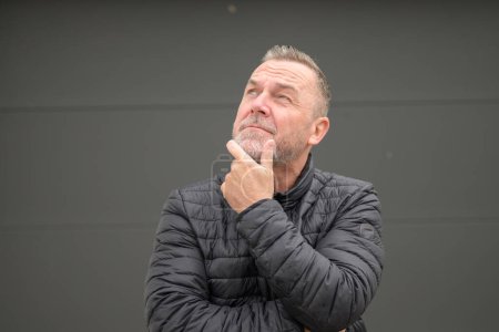 Photo for Middle age man holding his chin and looking to the sky - Royalty Free Image