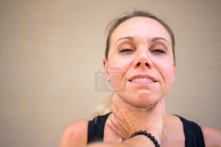 Photo for Pretty attractive woman with a mischievous smile is looking at the camera while a stranger's hand is on her neck - Royalty Free Image