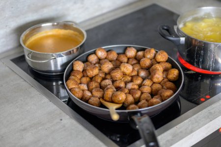 Foto de Vista lateral superior de una estufa con albóndigas suecas, papas y salsa marrón en concepto de cocina y alimentos - Imagen libre de derechos