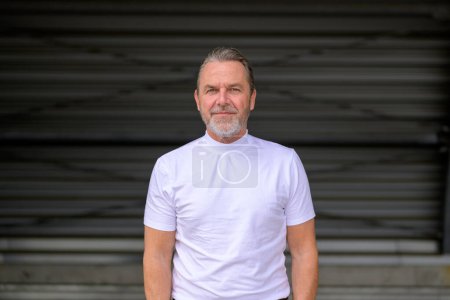 Téléchargez les photos : Vue de face d'un homme aux cheveux gris attrayant avec un T-shirt blanc - en image libre de droit