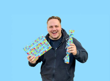 Foto de Joven feliz sosteniendo dos cajas azules con regalos y mirando a la cámara, en el estilo de candycore - Imagen libre de derechos