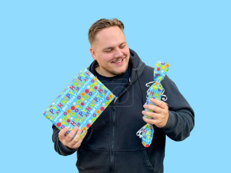 Foto de Un hombre sosteniendo dos cajas azules con regalos en ellas, al estilo de candycore - Imagen libre de derechos