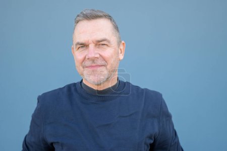 Photo for Close up portrait of a middle aged man looking friendly at the camera wearing a blue sweater - Royalty Free Image