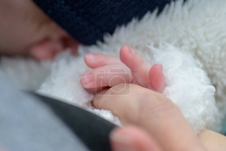 Photo for Extreme close up of the hand of little baby holding mothers hand with his little fingers outdoor - Royalty Free Image