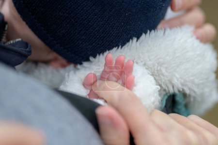 Téléchargez les photos : Gros plan de la main du petit bébé tenant la main des mères avec ses petits doigts en plein air - en image libre de droit