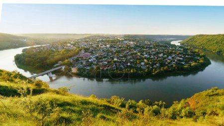 Photo for Sinuous river flowing through the canyon. Blue sky in sunny summer day. Dramatic and picturesque scene. Top panoramic view of Zalischyky town on Dnister river. Ukraine, Europe. - Royalty Free Image
