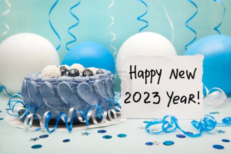 Foto de Feliz año nuevo 2023 - tarjeta con pastel y decoraciones de colores azul y blanco con globos de aire - Imagen libre de derechos