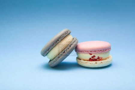 Foto de Dos colores macarons sobre fondo azul, hermoso postre y comida dulce - Imagen libre de derechos