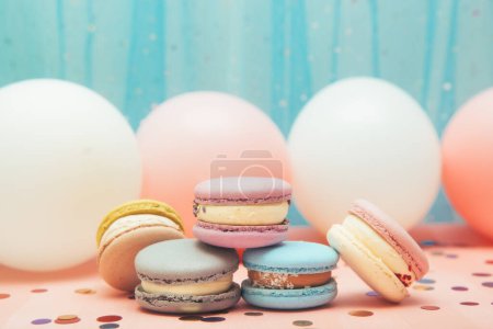 Foto de Pasteles de macarrones sobre fondo azul y rosa con globos aerostáticos, tarjeta de postre y decoración con espacio para copiar - Imagen libre de derechos