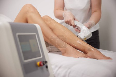 Photo for Laser epilation, Cosmetology and SPA, womans legs. Woman gets hair removed from legs with laser at spa, Laser epilation and cosmetology, Hair removal cosmetology procedure, Cosmetology SPA concept - Royalty Free Image