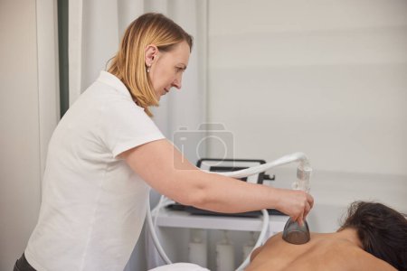 Photo for Problem areas, vacuum massage, Anti-cellulite. Anti-cellulite roller vacuum massage takes place in medicine salon. Slim problem areas, special body care professional equipment, perform lpg massage - Royalty Free Image
