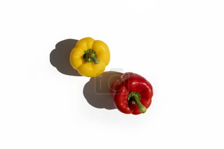 Foto de Yellow and red fresh paprika peppers on a white background. Top view, flat lay. - Imagen libre de derechos