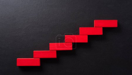 Concept of building success foundation. Yellow wooden block stacking as step stair, Success in business growth concept on yellow paper background.