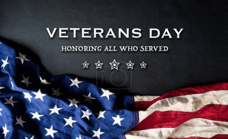 Happy Veterans Day Konzept mit Flagge der Vereinigten Staaten und dem Text auf schwarzem Holzgrund.