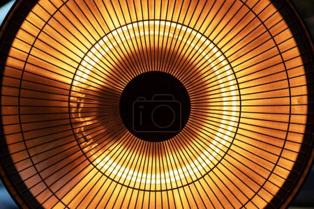 Photo for Detailed close up view of round electric heater in orange and yellow color as abstract tech background. - Royalty Free Image