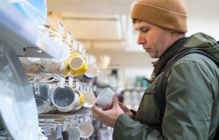 Man examining products on a store shelf with selective focus.