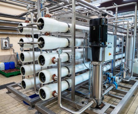 Reverse osmosis water treatment system with multiple filtration tubes in factory setting.
