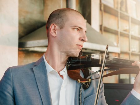 Téléchargez les photos : Violoniste performant avec violon électrique dans un cadre moderne. - en image libre de droit