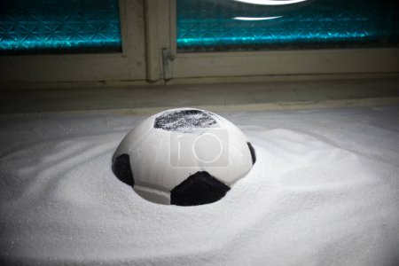 Photo for World cup at wintertime concept. Football (Soccer) ball on snowy decorated table with toy miniatures. New Year Christmas theme. Selective focus. Low light - Royalty Free Image