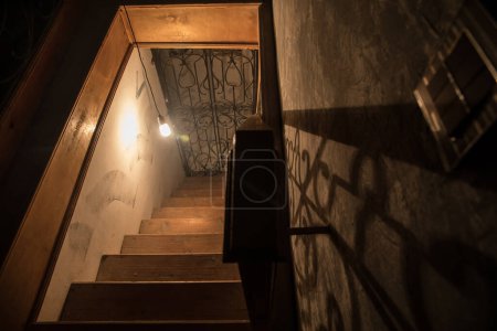 Téléchargez les photos : Escaliers en bois effrayant descendant vers le sous-sol dans une maison abandonnée. Horreur concept Halloween - en image libre de droit