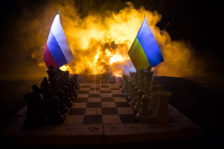 Foto de War between Russia and Ukraine, conceptual image of war using chess board, soldiers and national flags on the background of explosion. Ukrainian and Russian crisis. Selective focus - Imagen libre de derechos