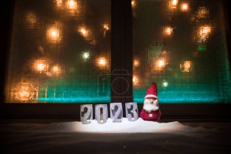 Photo for Happy New Year 2023. Traditional holiday attributes on snow. A greeting card for Christmas. Selective focus - Royalty Free Image