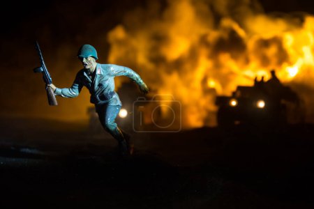 Téléchargez les photos : Guerre entre la Russie et l'Ukraine. Scène de bataille sur fond de brouillard de guerre, silhouettes de combat sous les nuages Skyline la nuit. Véhicule de l'armée avec décoration d'œuvres d'art des soldats. Concentration sélective - en image libre de droit