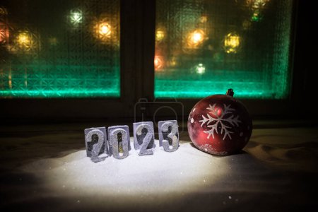 Foto de Feliz Año Nuevo 2023. Atributos tradicionales de vacaciones en la nieve. Una tarjeta de felicitación para Navidad. Enfoque selectivo - Imagen libre de derechos