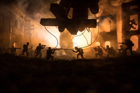 Concept of war or manipulation with global politics. The puppeteer controls soldiers. Night battle scene. Military fighting silhouettes in destroyed city. Selective focus