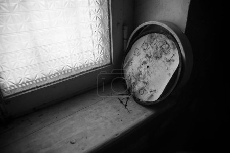 Foto de Old and vintage blank clock dial without hand on old wooden windowsill. Studio shot - Imagen libre de derechos
