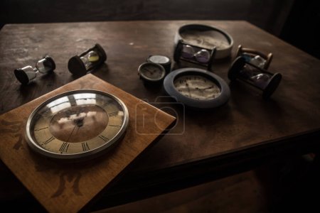 Foto de Concepto de tiempo. Muchos relojes en la vieja mesa de madera con espacio de copia plano de estudio - Imagen libre de derechos