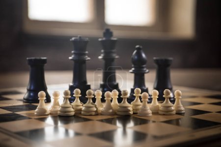 Foto de Juego de mesa de ajedrez concepto de ideas de negocio, competencia y estrategia. Figuras de ajedrez sobre un fondo oscuro con humo y niebla. Enfoque selectivo - Imagen libre de derechos