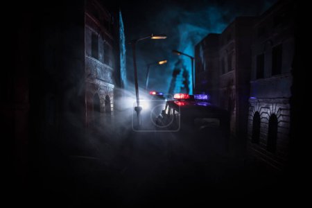 Polizeirazzia in der Nacht und Sie stehen unter Arrest. Silhouette eines Polizeiwagens auf der Rückseite. Bild mit den blinkenden roten und blauen Polizeilichtern vor nebligem Hintergrund.
