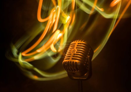 Photo for Microphone for sound, music, karaoke in audio studio or stage. Mic technology. Speech broadcast equipment. Microphone in dark room on table with backlight. Selective focus - Royalty Free Image