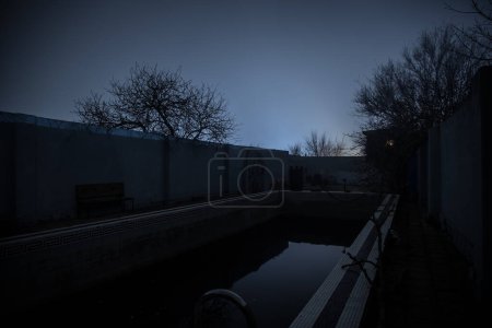Foto de Piscina abandonada por la noche. Una antigua piscina en el jardín. Disparo de obturador largo - Imagen libre de derechos