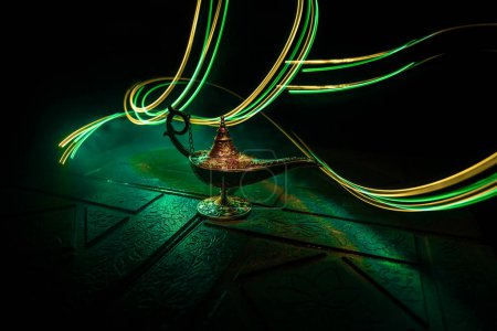 Photo for Antique Aladdin arabian nights genie style oil lamp with soft light white smoke, Dark background. Lamp of wishes concept - Royalty Free Image