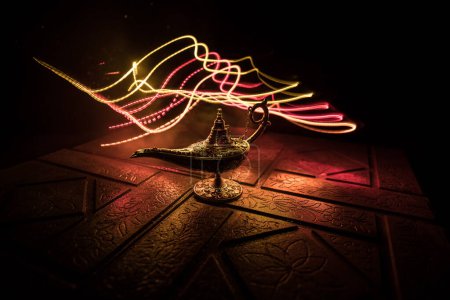 Foto de Antiguo Aladdin noches árabes lámpara de aceite de estilo genio con humo blanco claro suave, fondo oscuro. Concepto de lámpara de deseos - Imagen libre de derechos