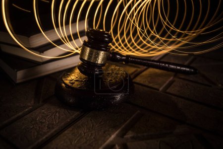 Photo for Law theme, mallet of the judge on wooden desk. Law gavel on dark foggy background with light. Selective focus - Royalty Free Image