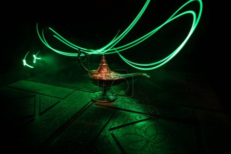 Téléchargez les photos : Antique Aladdin arabian nuits lampe à huile de style génie avec fumée blanche douce lumière, fond foncé. Concept Lampe de voeux - en image libre de droit