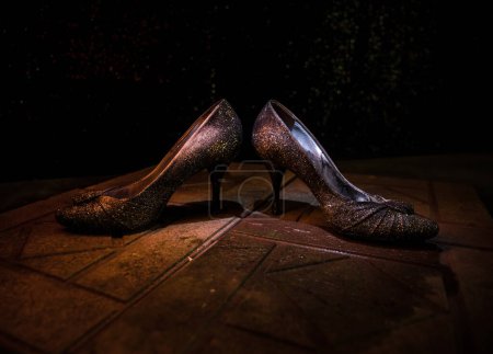 Foto de Decoración de obra. Silueta de un tacón alto zapatos de mujer en la oscuridad. Concepto de poder femenino o dominación femenina. Enfoque selectivo - Imagen libre de derechos