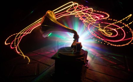 Photo for Music concept. Old gramophone on a dark background. Retro gramophone with disc on wooden table with toned backlight. Selective focus - Royalty Free Image