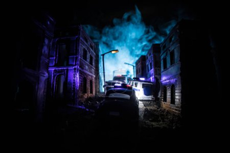 Foto de Police raid at night and you are under arrest concept. Silhouette of police car on backside. Image with the flashing red and blue police lights at foggy background. - Imagen libre de derechos