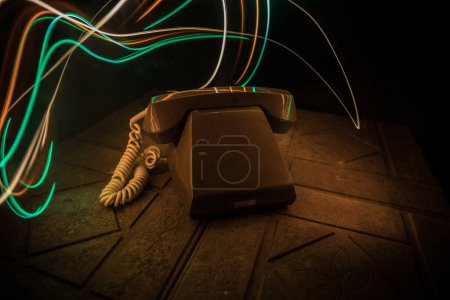 Photo for Old telephone without numbers on old wood plank with art dark background with fog and toned light. empty space. Selective focus - Royalty Free Image