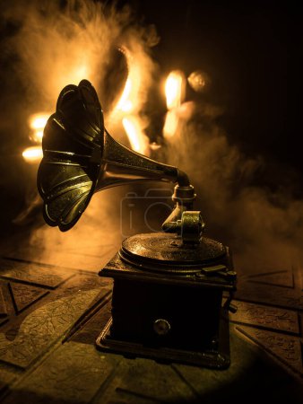Photo for Music concept. Old gramophone on a dark background. Retro gramophone with disc on wooden table with toned backlight. Selective focus - Royalty Free Image